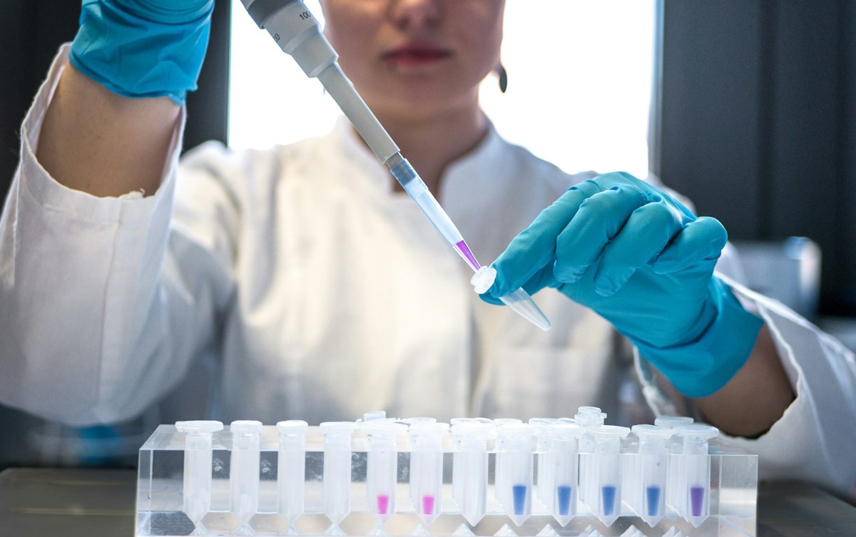 Researcher using a pipette in a laboratory. Illustrative stock photograph.